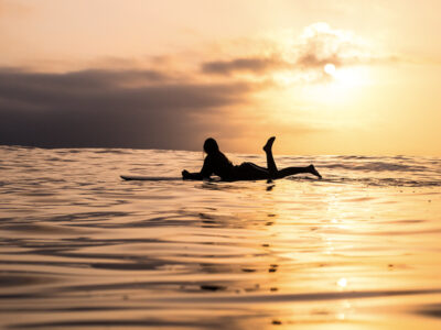 girl surfing with sunset view