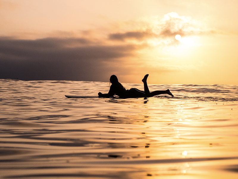 girl surfing with sunset view
